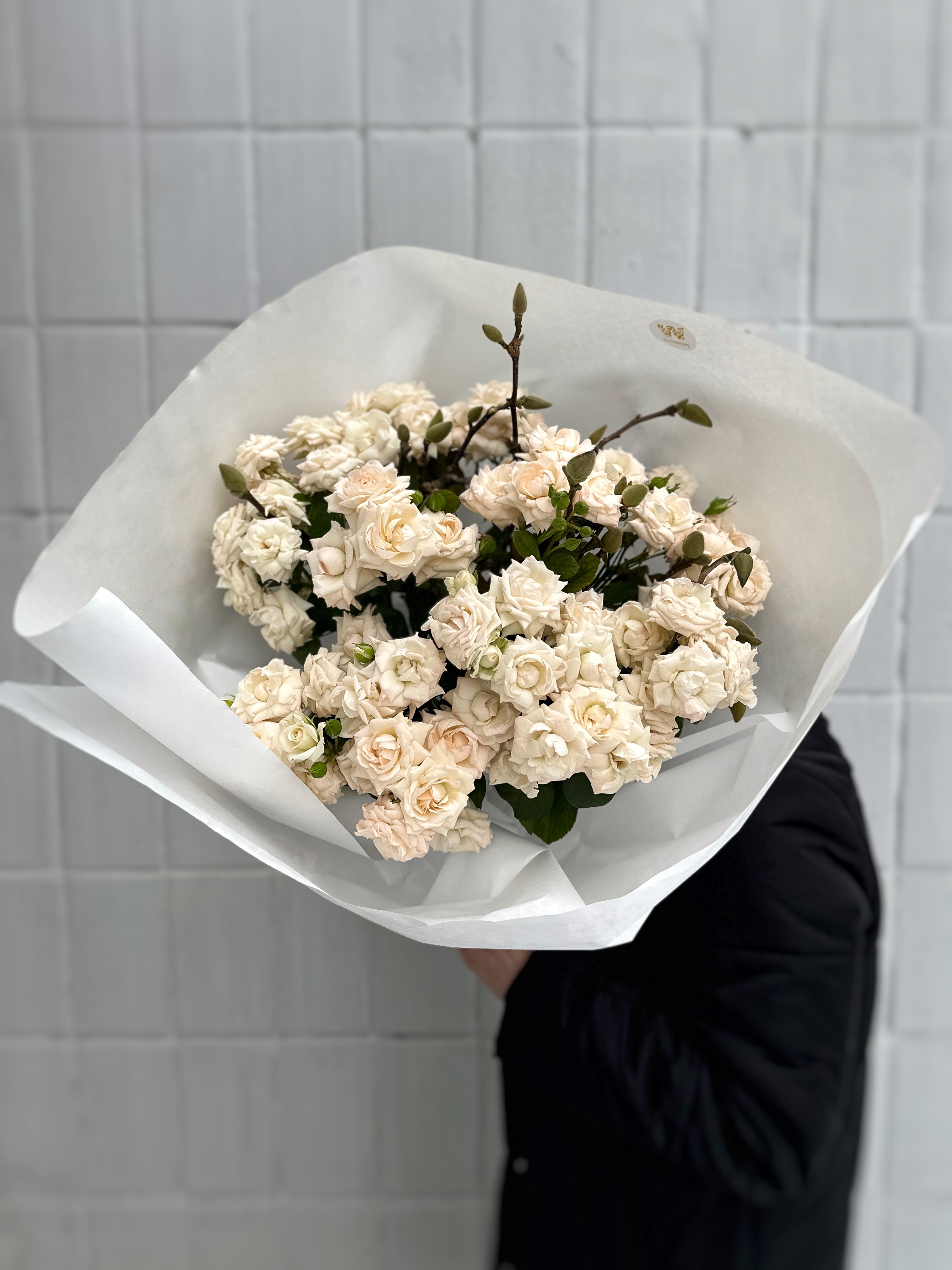 Букет из 15 кустовых роз и веток магнолии